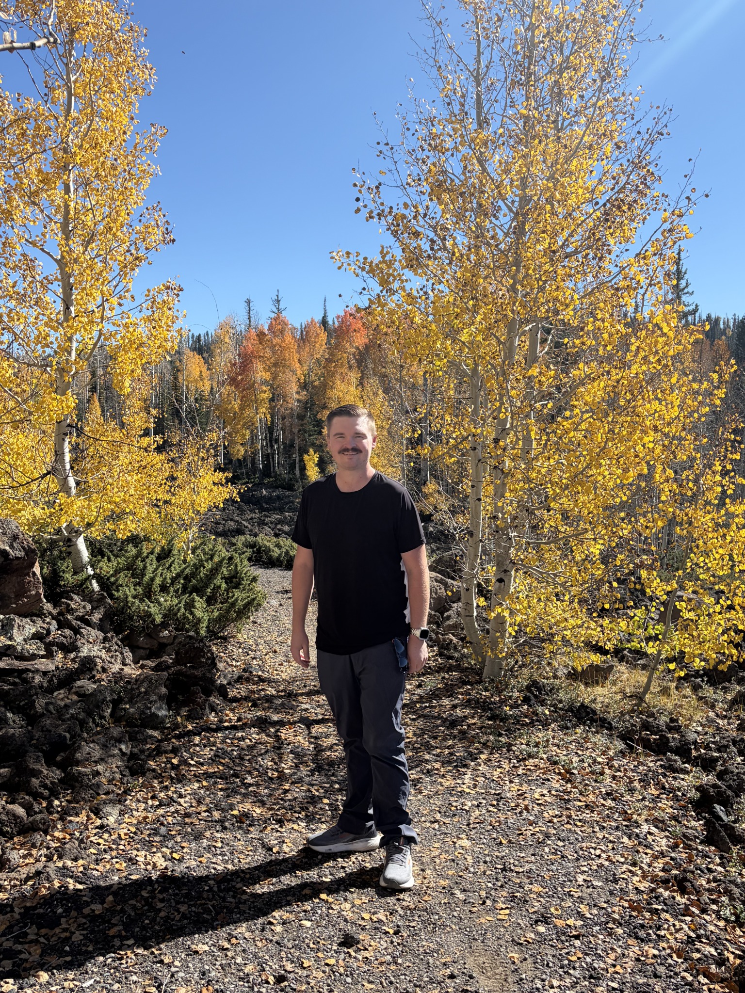 Joshua standing on a trail among golden autumn trees
